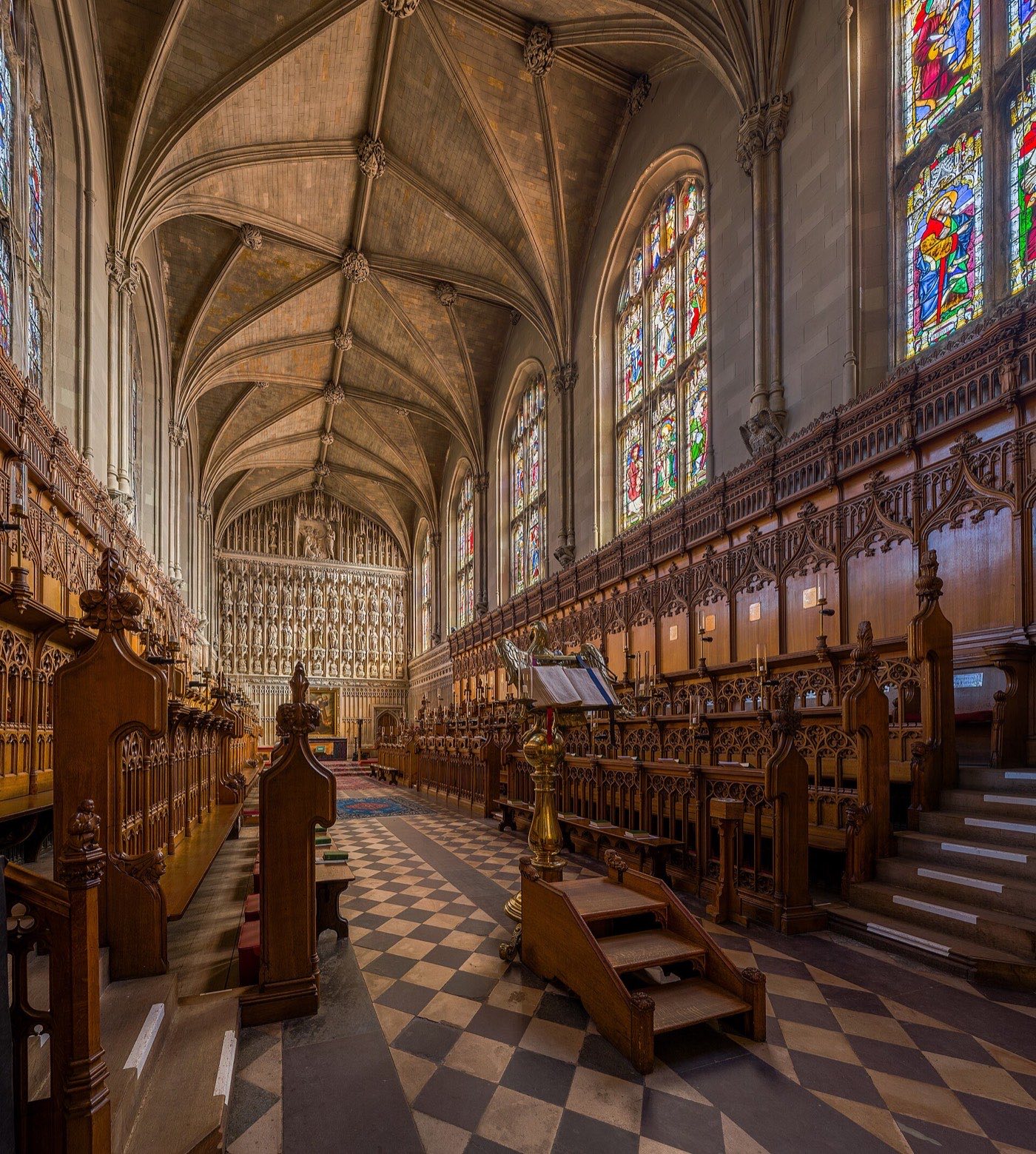 Intérieur gothique de la chapelle de Magdalen College à Oxford, stalles de bois sculpté et hauts vitraux.