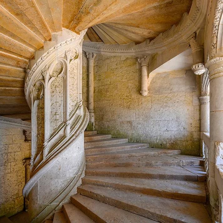 L'escalier en vis de l'aile Renaissance de Châteaudun, sa rampe sculptée et ses fines colonnes